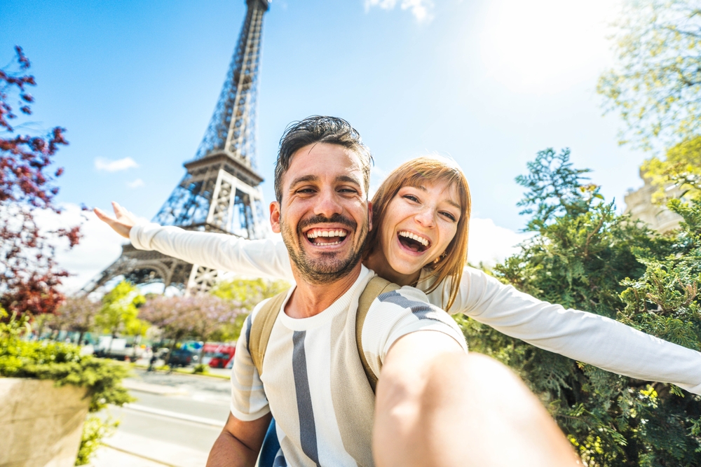 tourists taking selfie picture in front of Eiffel Tower in Paris, France