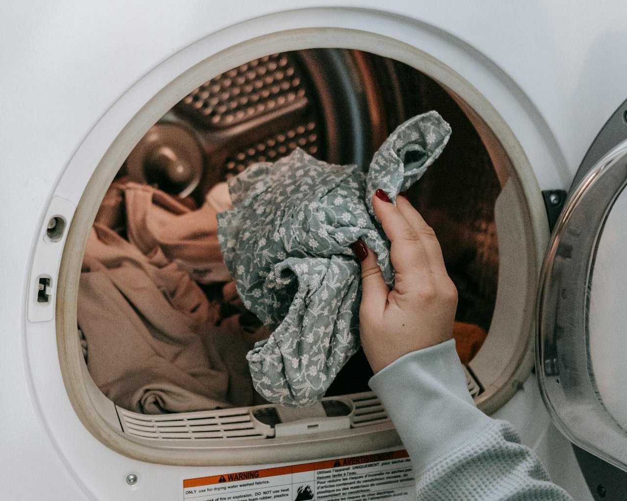 Anonymous woman putting clothes in washing machine