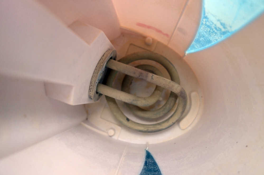 The interior of an electric kettle with a stone on the radiator.