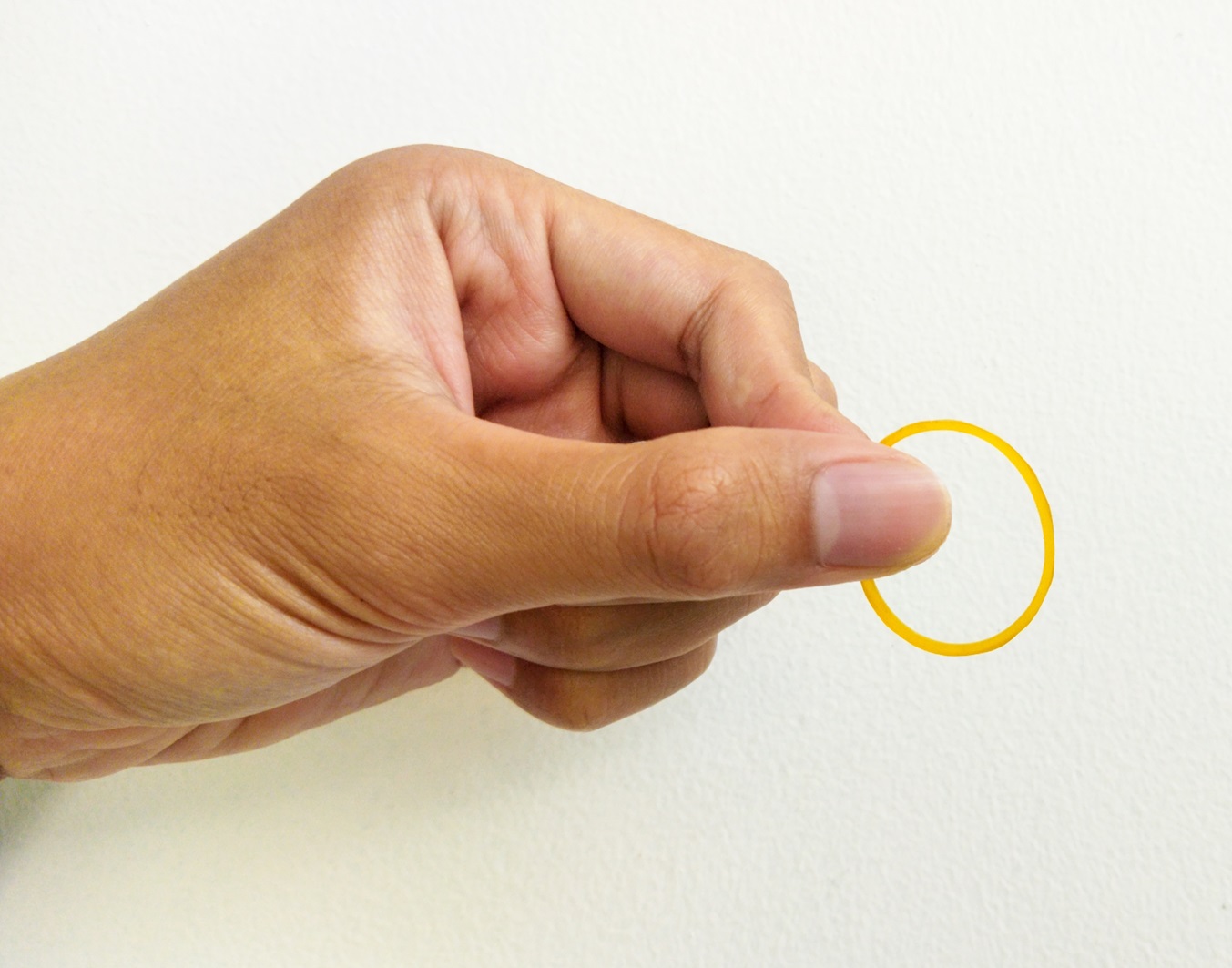 Hand playing with elastic hair band on isolated white background
