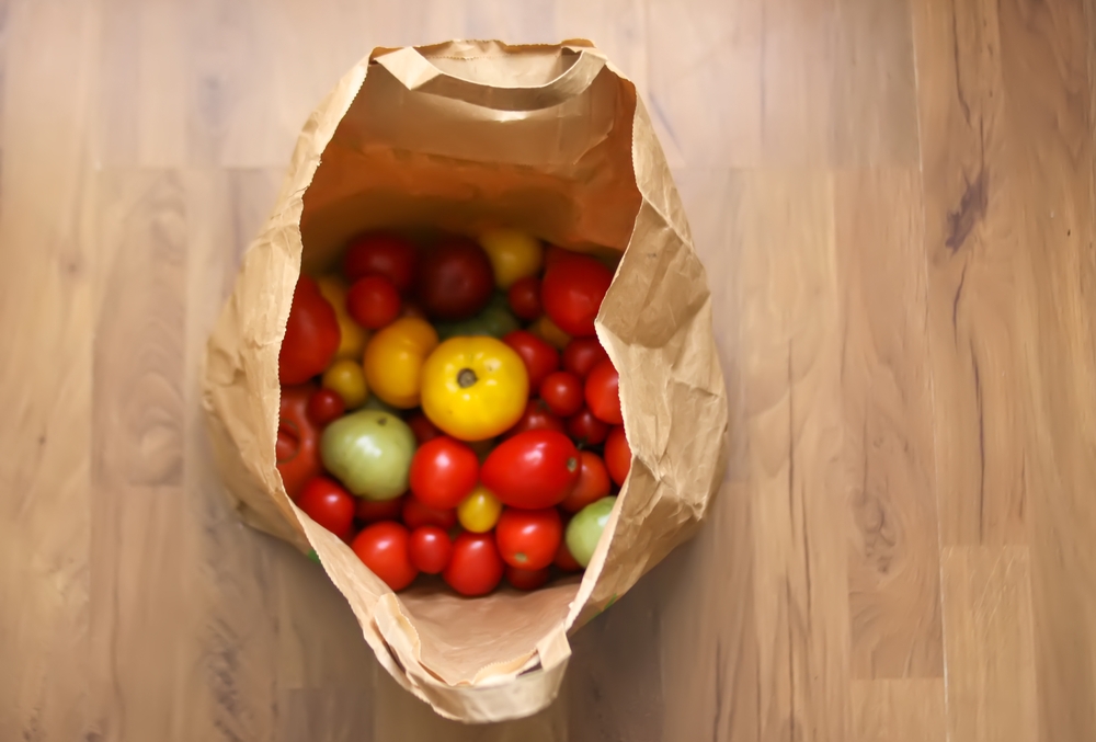 Paper bag with fresh ripe tomatoes.