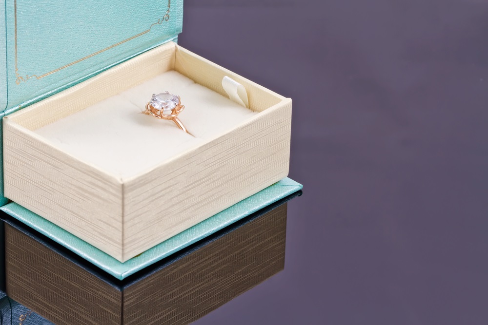A gold ring with a precious stone in a gift box in the form of books