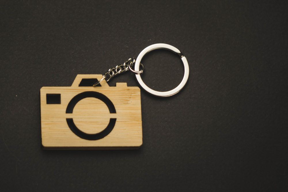 wooden trinket in the form of a camera on a black background. keychain