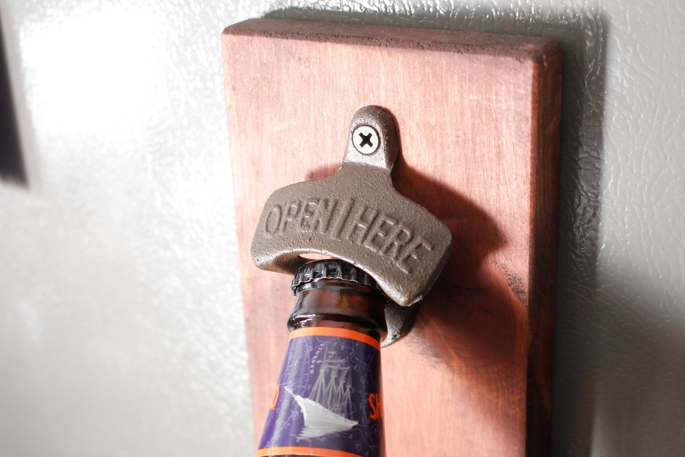 A closeup view of a wall mounted bottle opener.