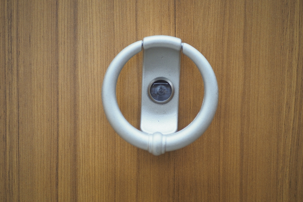 Classic door knocker on a wood background