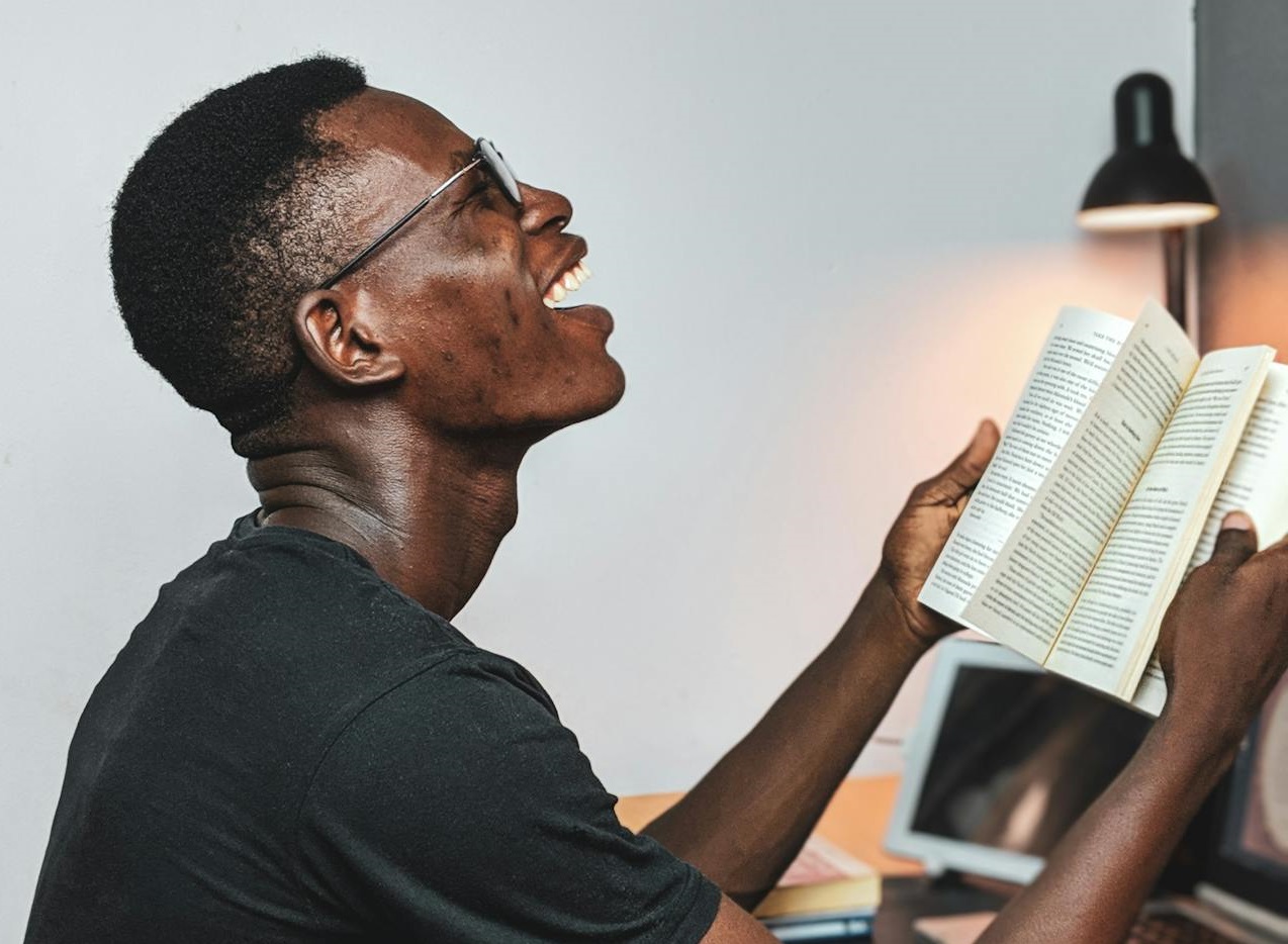 Smiling Man Reading A Book.