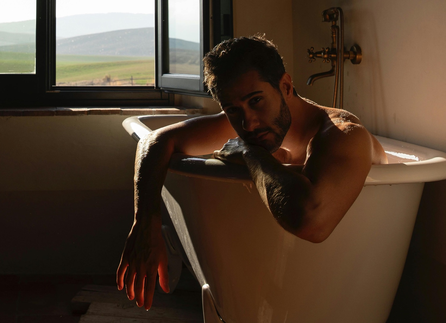 Man Sitting in a Bath by the Window