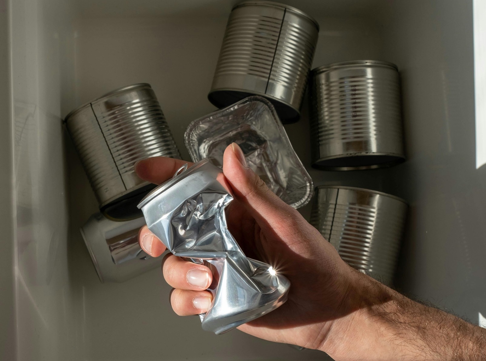 A Person Holding a Crushed Can
