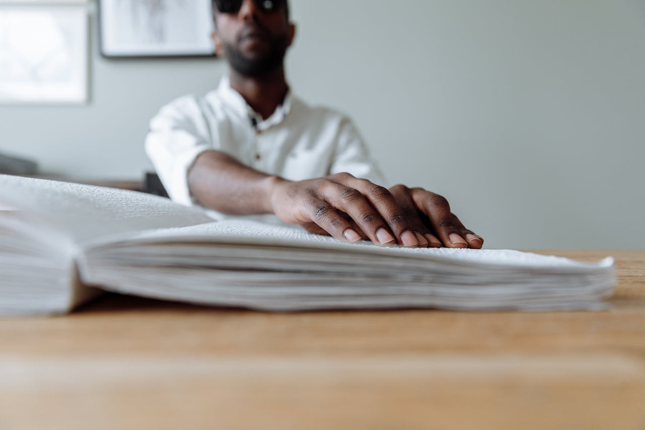 Man Reading Book Written with Braille