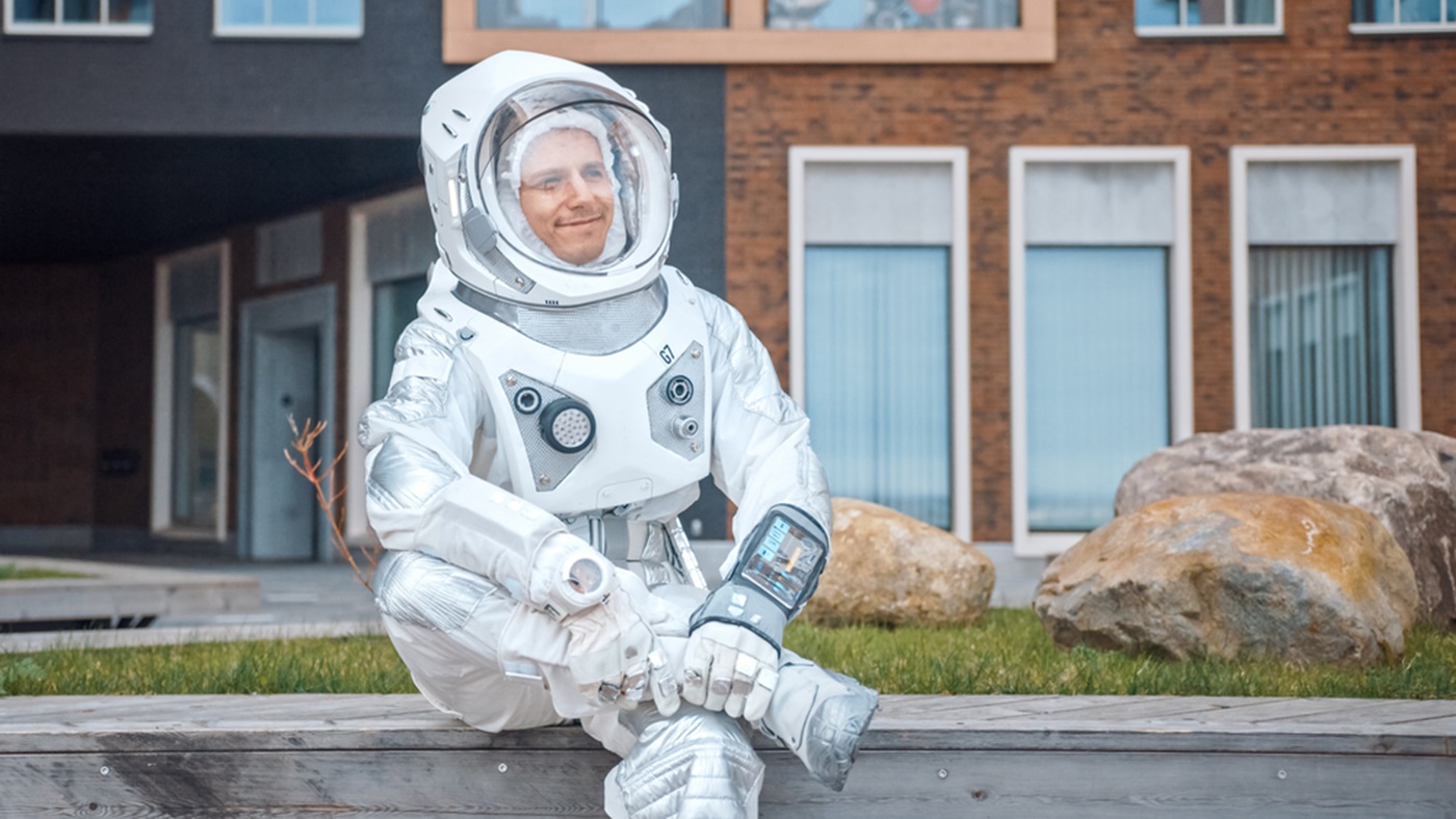 Happy Man in Spacesuit is Sitting on Wooden Bench.