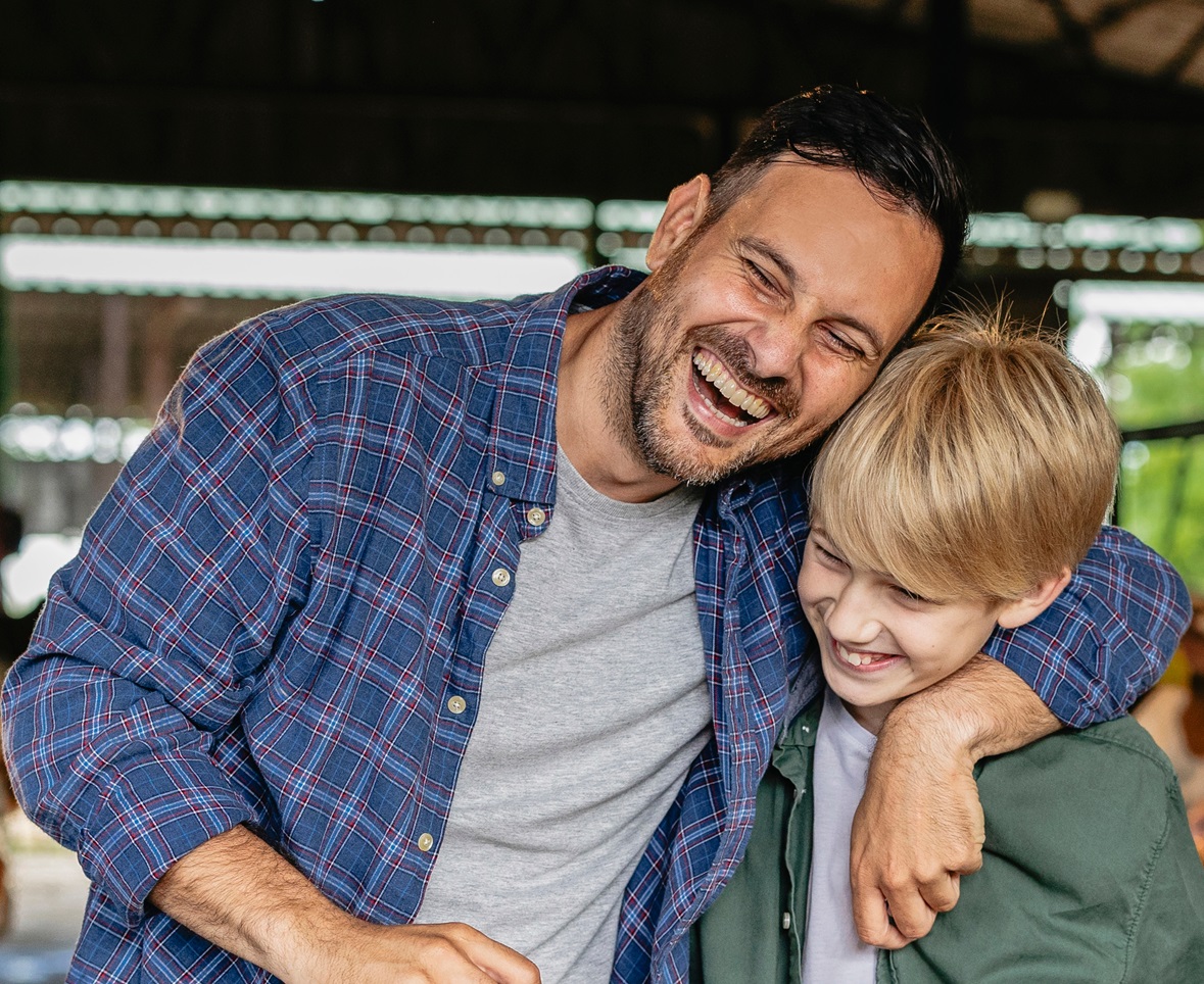 Father and son laughing together in a barn