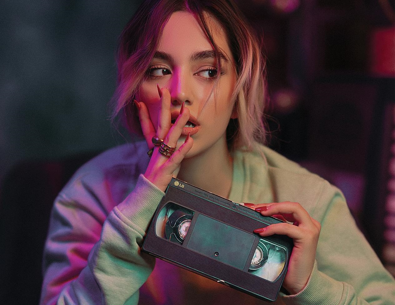A Woman in Gray Sweater Holding a Vhs Tape