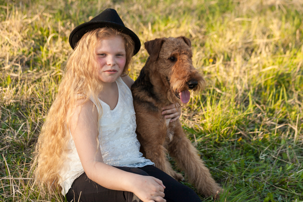 Girl teenager sitting and relaxing with her dog airedale terrier