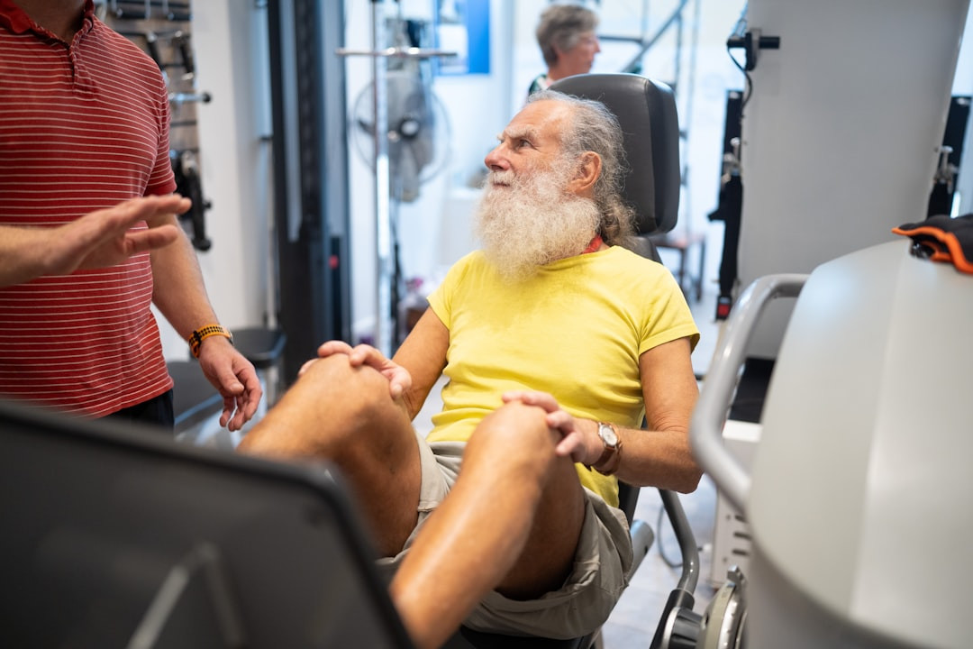 a man with a white beard sitting in a gym