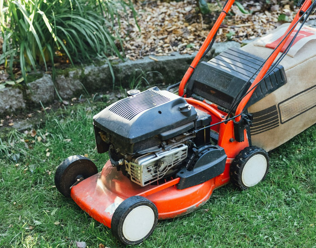 A lawn mower sitting on top of a lush green field