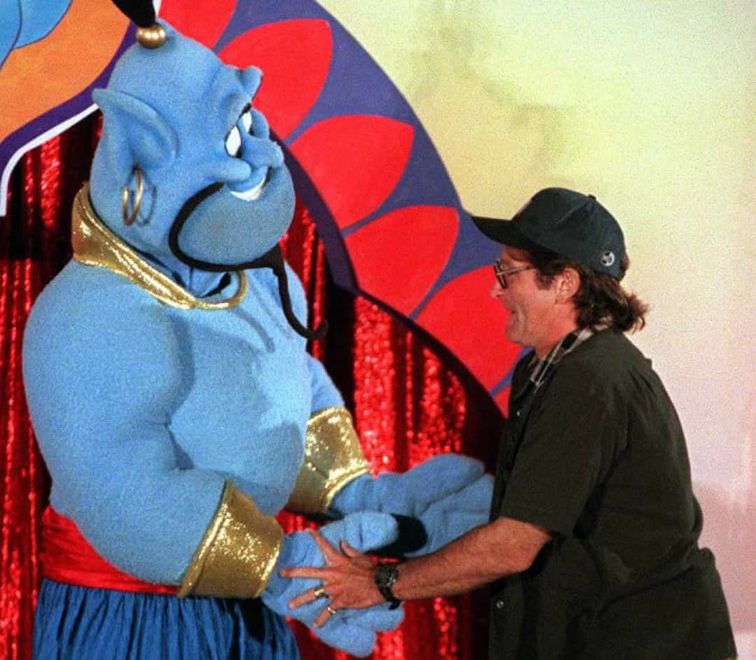 Actor Robin Williams dancing with 'Ghost from the lamp' mascot.