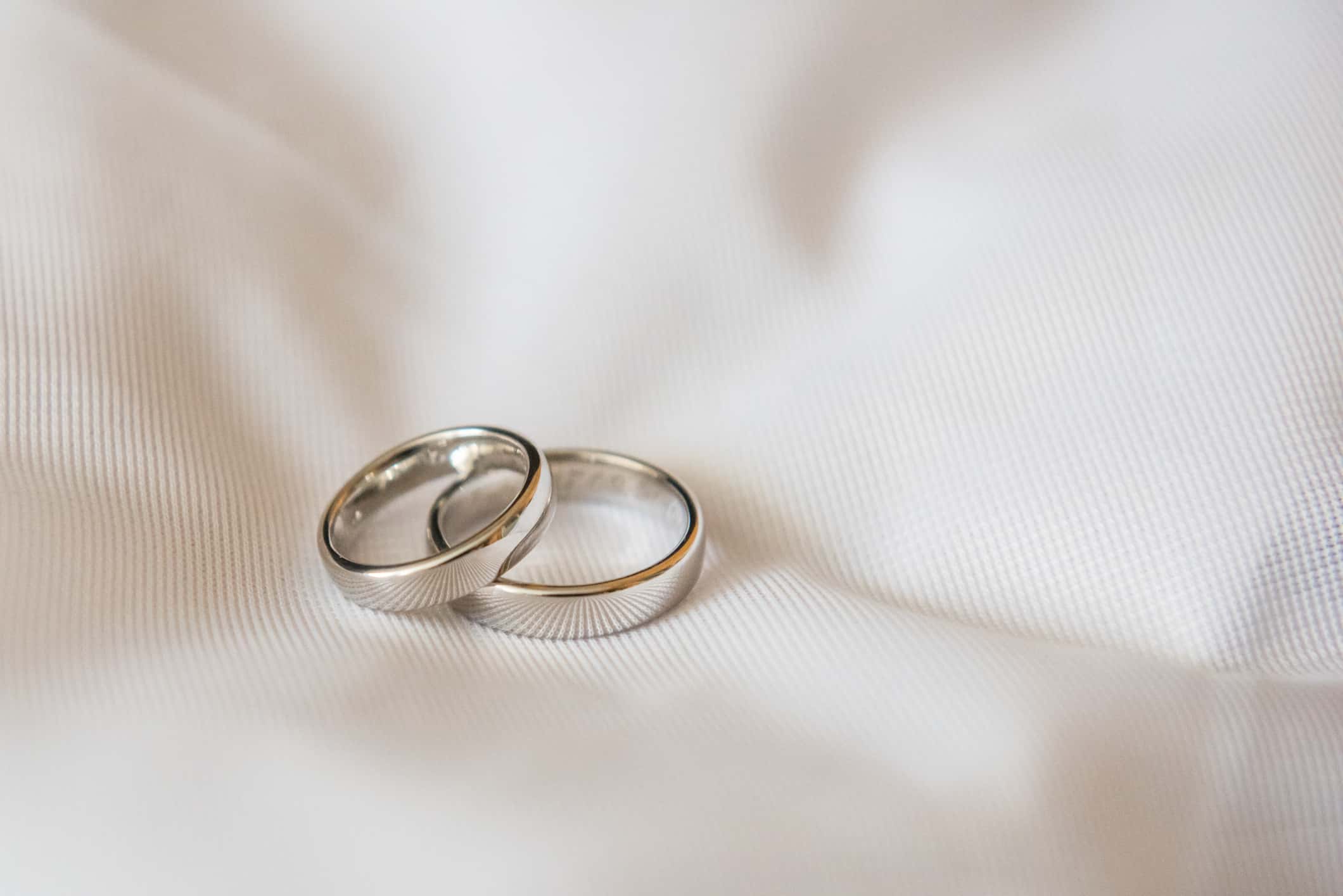 Close-Up Of Wedding Rings On Tablecloth