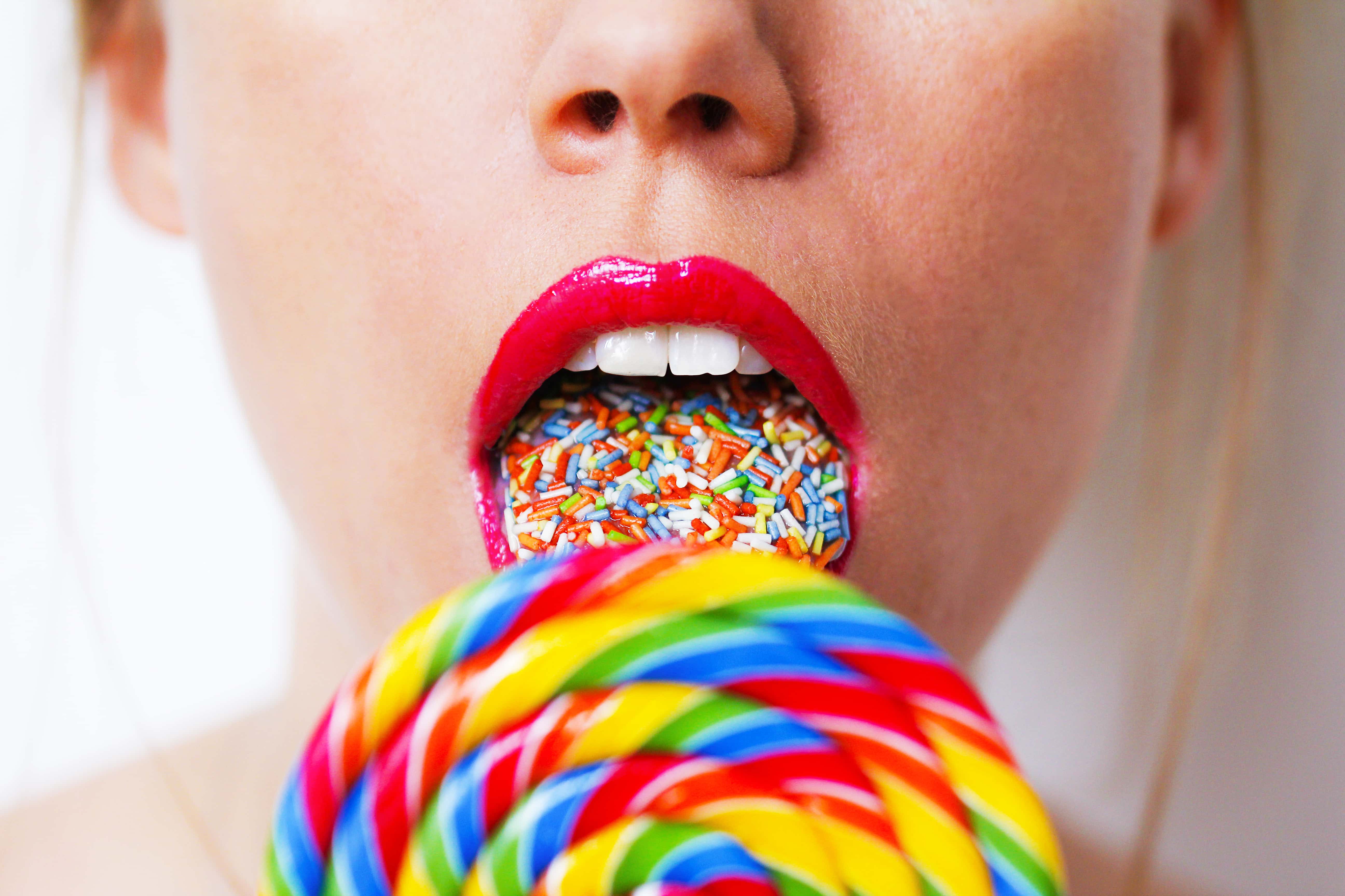 Woman licking colourful lollipop