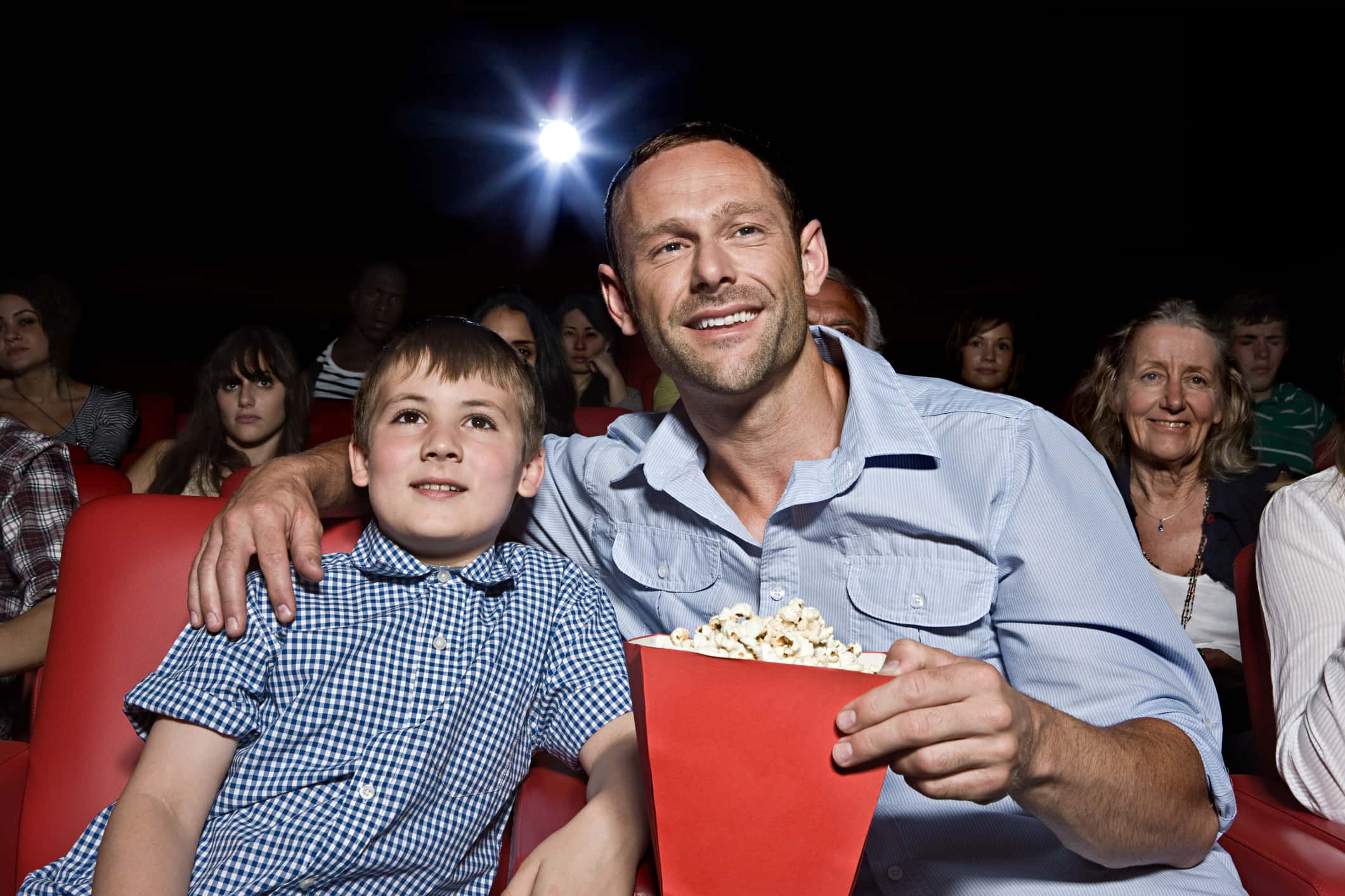 Father and son enjoying a movie.